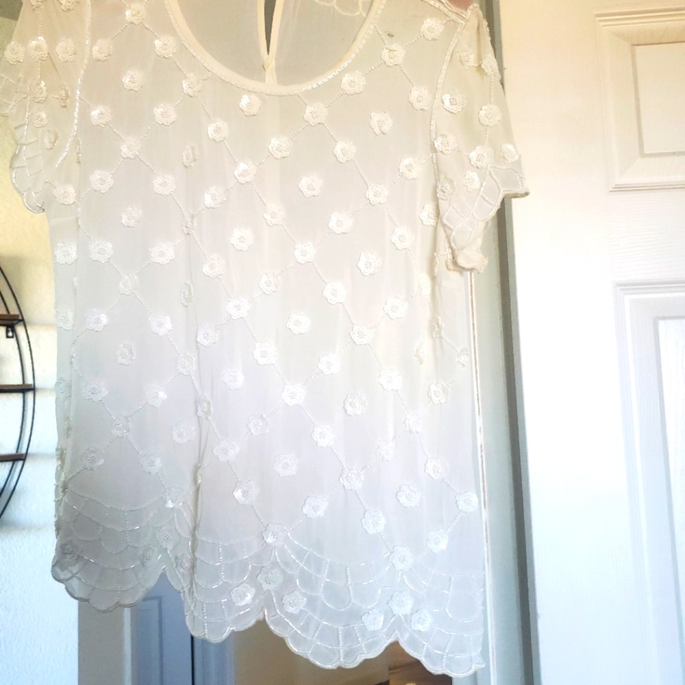 White sheer top with beaded flowers.